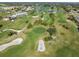 Aerial view of a scenic golf course featuring lush green fairways, mature trees, and strategically placed sand bunkers at 26090 Rampart Blvd, Punta Gorda, FL 33983