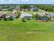 Aerial view of homes with green lawns, swimming pools, and screened-in lanais in a sunny, well-maintained neighborhood at 26090 Rampart Blvd, Punta Gorda, FL 33983