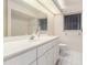 Bright bathroom features a large vanity, mirror, a window, and tiled floors at 26090 Rampart Blvd, Punta Gorda, FL 33983