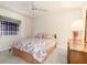Cozy bedroom features a queen bed, ceiling fan, and an exterior window at 26090 Rampart Blvd, Punta Gorda, FL 33983