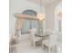 Dining room features a glass table, seating for four, and stylish sheer fabric window treatments at 26090 Rampart Blvd, Punta Gorda, FL 33983