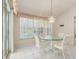 Cozy dining area with a glass table, white chairs, and a window overlooking the outdoor space at 26090 Rampart Blvd, Punta Gorda, FL 33983