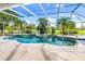 Sparkling pool within screened enclosure, adorned with palm trees and landscaping for a private oasis at 26090 Rampart Blvd, Punta Gorda, FL 33983