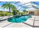 Gorgeous in-ground pool with a spa surrounded by stone and a screened-in patio at 26090 Rampart Blvd, Punta Gorda, FL 33983