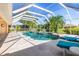 Large screened-in pool with palms and a spa surrounded by blue lounge chairs at 26090 Rampart Blvd, Punta Gorda, FL 33983