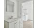 Bathroom with a white vanity, mirror, and a view into an adjacent room at 2626 E 38Th Ave, Tampa, FL 33610
