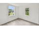 Cozy bedroom with laminate flooring, two windows, and freshly painted white walls at 2626 E 38Th Ave, Tampa, FL 33610