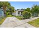 Side yard exterior with a chain-link fence, lovely flowers, and off-street parking at 2626 E 38Th Ave, Tampa, FL 33610