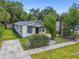 Inviting bungalow featuring a quaint front yard with stone pathway and vibrant, mature landscaping at 2626 E 38Th Ave, Tampa, FL 33610