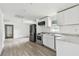 Open kitchen featuring stainless appliances, white cabinetry, and laminate floors at 2626 E 38Th Ave, Tampa, FL 33610