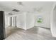 Bright living room featuring neutral paint, modern ceiling fan, and light gray laminate flooring at 2626 E 38Th Ave, Tampa, FL 33610