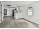 Bright, open living space with wood floors, white walls, and a kitchen area with stainless steel appliances at 2626 E 38Th Ave, Tampa, FL 33610