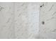 Close-up of a modern shower featuring marble-patterned tile and sleek fixtures at 2626 E 38Th Ave, Tampa, FL 33610