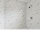A bathroom shower with marble-patterned tile at 2626 E 38Th Ave, Tampa, FL 33610