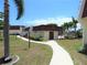 Serene walkway leading to condos, enhanced by lush landscaping and vibrant flowers with community pool nearby at 311 Garvin St # 301B, Punta Gorda, FL 33950