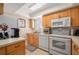 Well-lit kitchen with white appliances, wood cabinets, and a view of the backyard at 311 Garvin St # 301B, Punta Gorda, FL 33950