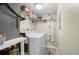 Bright laundry room with white washer and dryer, shelving and cleaning supplies for convenient home care at 311 Garvin St # 301B, Punta Gorda, FL 33950