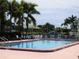 Community pool surrounded by lounge chairs and tropical landscaping overlooking the canal at 311 Garvin St # 301B, Punta Gorda, FL 33950