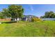 Expansive backyard featuring a screened-in pool, a large tree and a partial fence at 3270 Ithaca St, Port Charlotte, FL 33952