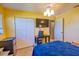 Bright bedroom featuring yellow walls, a ceiling fan, and a TV mounted above a black table and a white closet at 3270 Ithaca St, Port Charlotte, FL 33952