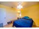 Cozy bedroom with yellow walls, a ceiling fan, and a bed with blue comforter, creating a relaxing atmosphere at 3270 Ithaca St, Port Charlotte, FL 33952