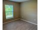 Neutral bedroom featuring wood-look floors, a window with blinds, and a light-tone wall color at 3532 Richardson St, North Port, FL 34288