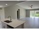 Bright kitchen with island and sink overlooking the living area, featuring sleek wood-look floors and vaulted ceilings at 3532 Richardson St, North Port, FL 34288
