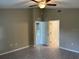Main bedroom features wood-look floors, a ceiling fan, and open doorways to an ensuite bathroom at 3532 Richardson St, North Port, FL 34288