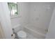 Cozy bathroom featuring a tub with white tiled walls, a toilet, and a window providing natural light at 3588 Tripoli Blvd, Punta Gorda, FL 33950