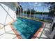 Inviting screened-in pool with brick accents and tranquil water views overlooking the canal at 3588 Tripoli Blvd, Punta Gorda, FL 33950