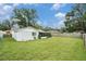 Landscaped backyard featuring a well-maintained lawn, screened porch, and partial fencing at 3612 Patina Dr, Tampa, FL 33619