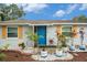 Inviting front entry with a vibrant blue door, complemented by colorful plants and landscape at 3612 Patina Dr, Tampa, FL 33619
