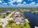 Stunning aerial view of a waterfront home featuring a private pool, boat dock, lush landscaping, and serene canal access at 4142 Reif Ct, Port Charlotte, FL 33981