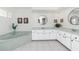 Bright bathroom features a soaking tub, white cabinetry, and decorative mirrors at 4142 Reif Ct, Port Charlotte, FL 33981