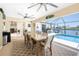 Enclosed dining area featuring a large table, ceiling fans, and views of the pool and waterfront at 4142 Reif Ct, Port Charlotte, FL 33981