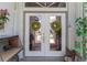 Elegant double front doors are adorned with decorative wreaths, creating a warm and inviting entrance to the home at 4142 Reif Ct, Port Charlotte, FL 33981