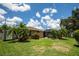 Lush backyard with green lawn, palm trees, and screened-in pool is perfect for outdoor enjoyment at 4640 W Price Blvd, North Port, FL 34286