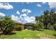 Large, green backyard with palms, a screened pool, and lawn offers relaxation and entertainment at 4640 W Price Blvd, North Port, FL 34286