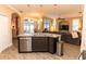 The kitchen island has a stainless steel dishwasher, dark cabinets, granite countertops, and wood-look tile at 4640 W Price Blvd, North Port, FL 34286
