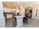 Open kitchen with stainless steel appliances, island bar, and granite counters, seamlessly flowing into the living areas at 4640 W Price Blvd, North Port, FL 34286