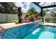 Captivating pool area featuring a tiled waterfall and decorative statuary, and serene turquoise water at 4640 W Price Blvd, North Port, FL 34286
