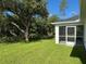 View of the back of house with screened in porch and grassy lawn at 4863 Las Almanos Ave, North Port, FL 34288