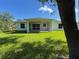 View of the back of house with screened in porch and grassy lawn at 4863 Las Almanos Ave, North Port, FL 34288