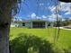 View of the backyard and house from behind a tree at 4895 Las Almanos Ave, North Port, FL 34288