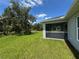 View of the backyard and screened in porch from the grass at 4895 Las Almanos Ave, North Port, FL 34288