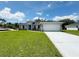 Charming single-story home with well-manicured lawn and a two-car garage on a bright sunny day at 4895 Las Almanos Ave, North Port, FL 34288