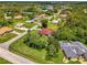 Scenic aerial view of a red roof home with a screened pool nestled in a neighborhood with mature trees at 510 Border St, Port Charlotte, FL 33953
