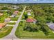 Expansive aerial view of a home with a red tile roof, blue pool, mature landscaping and green lawns at 510 Border St, Port Charlotte, FL 33953