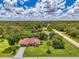 Picturesque aerial view highlighting a home's well-maintained lawn, red roof, screened pool, and long driveway at 510 Border St, Port Charlotte, FL 33953