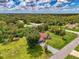 Aerial perspective featuring a red roof home with screened pool, surrounded by lush landscape and a long driveway at 510 Border St, Port Charlotte, FL 33953
